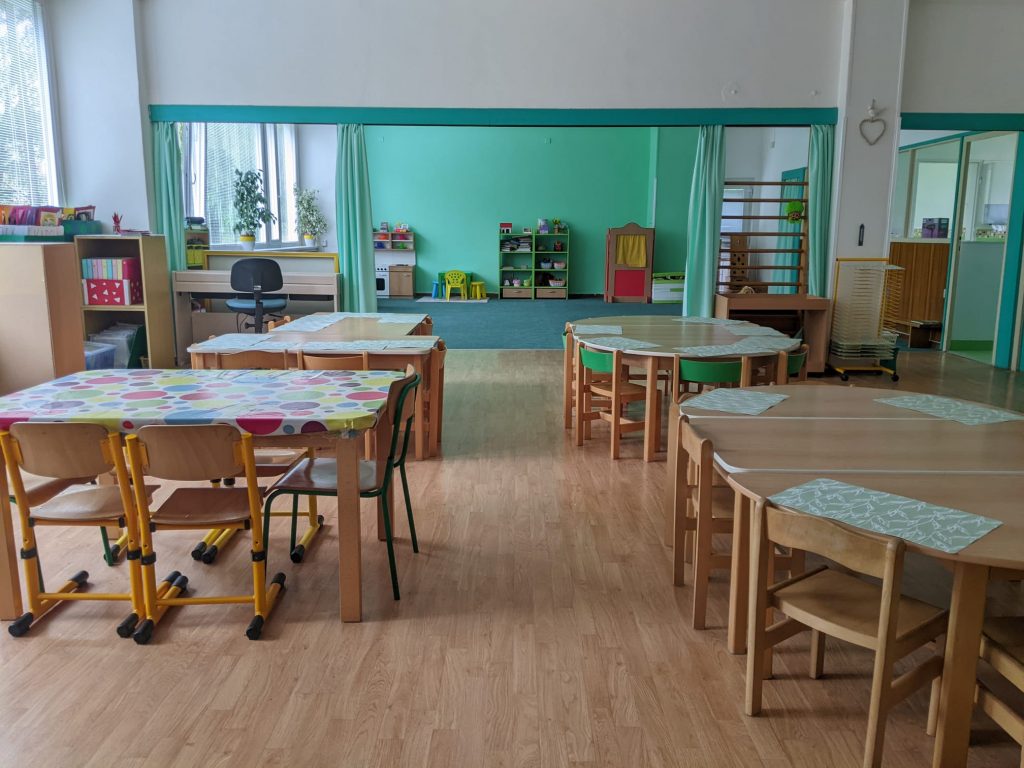 Třída se stolky a herním koutem se žebřinami a loutkovým divadlem
